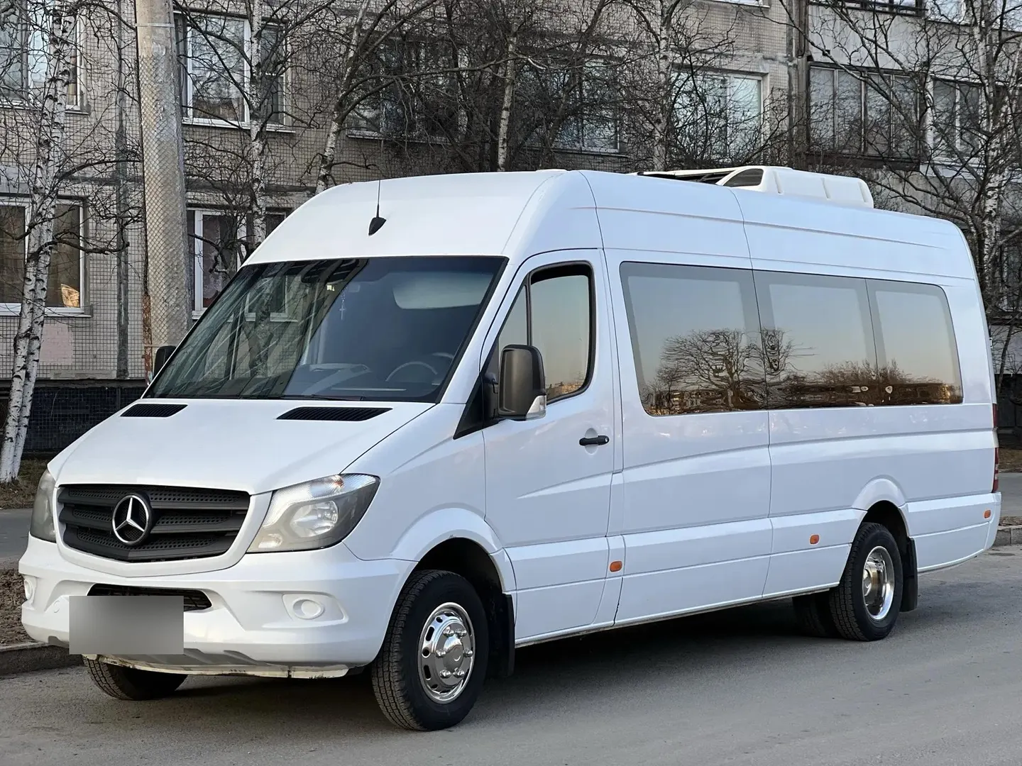Xe 19 chỗ Mercedes-Benz Sprinter màu trắng, điều hoà trên nóc, đỗ trên phố ở Saint Petersburg